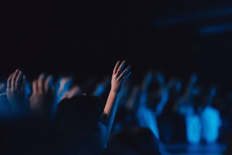 Believers in worship gathered in a hall with blue light effect